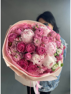 A bouquet of peonies and spray roses in pink shades